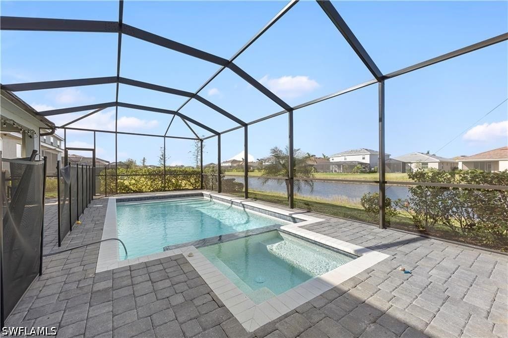 Screened lanai featuring a swimming pool, integrated spa, and paver decking
