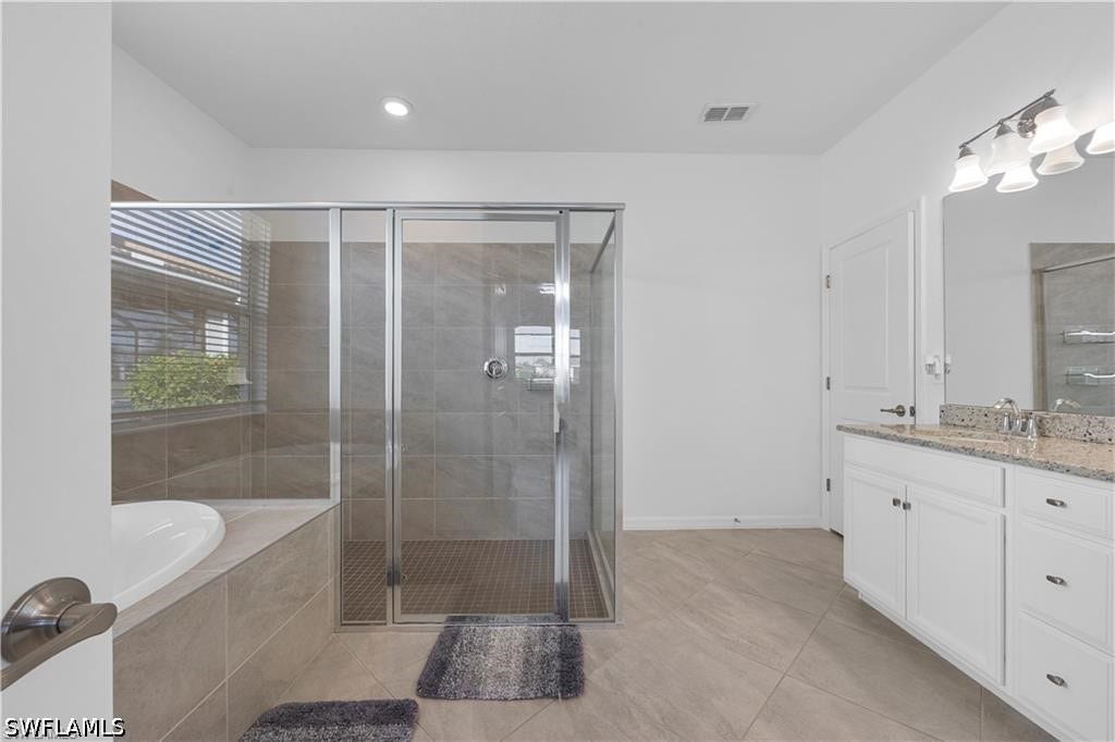 Walk-in shower with clear glass enclosure and tile surround