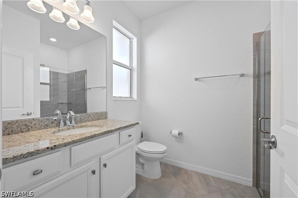 White vanity with a stone-finish countertop and integrated sink
