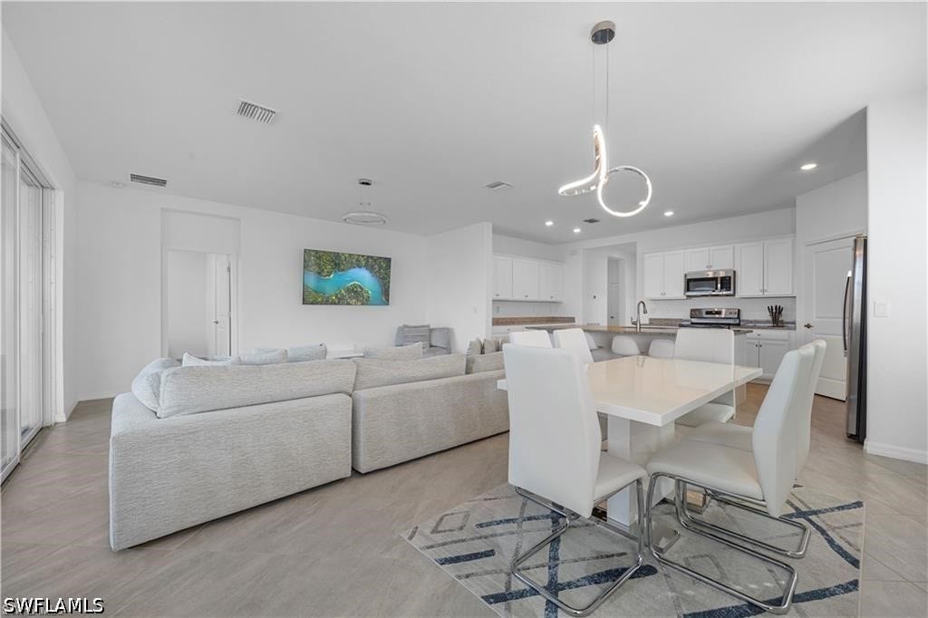 Open-concept living space featuring a modern kitchen, dining area, and living room