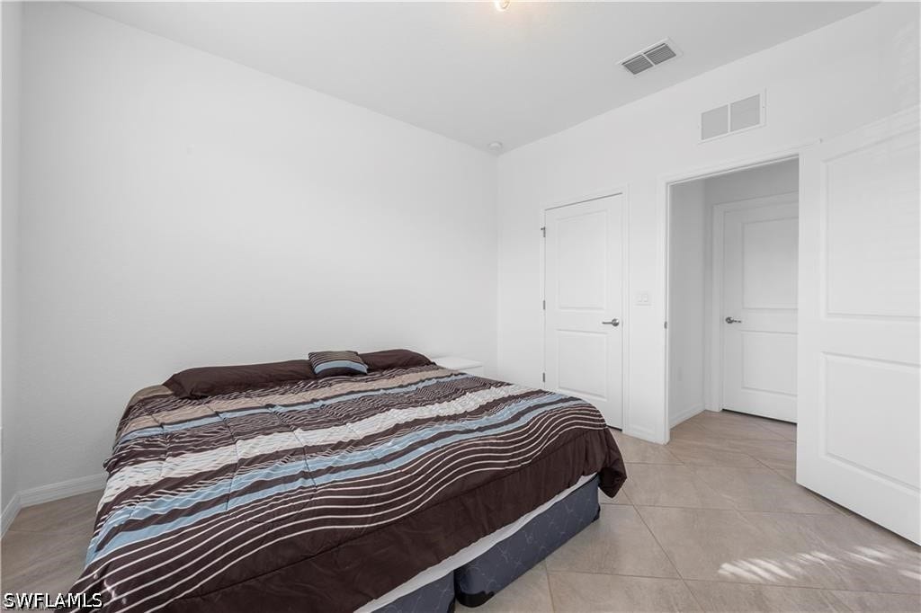 White interior walls, tile flooring, and white panel doors