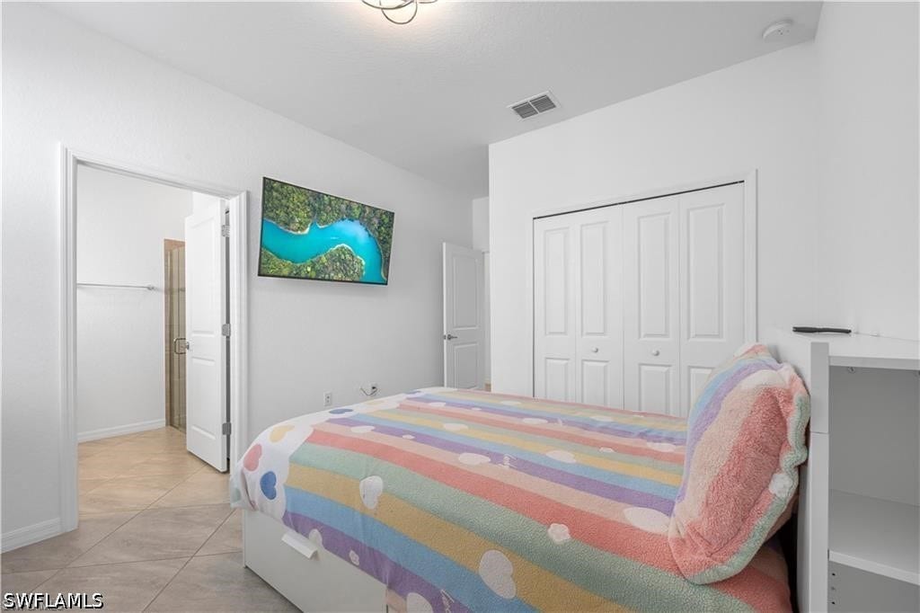 White interior walls, bi-fold closet doors, recessed lighting, and tile flooring