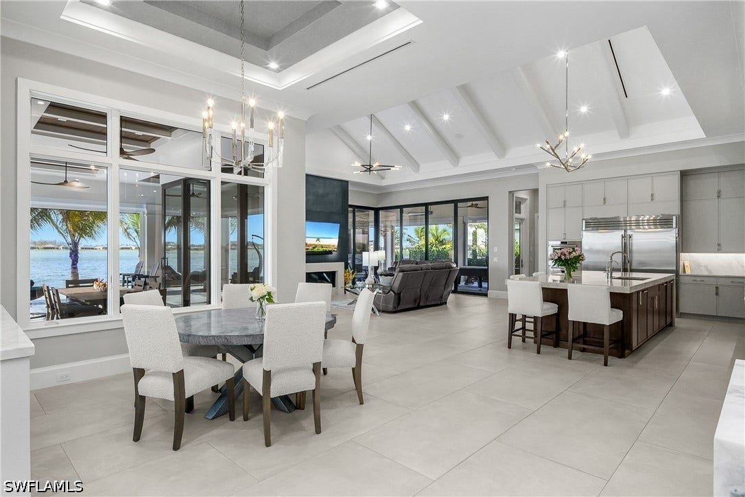 Dedicated dining space with lighted coffered ceiling and custom lighting is just steps from the gourmet custom kitchen.