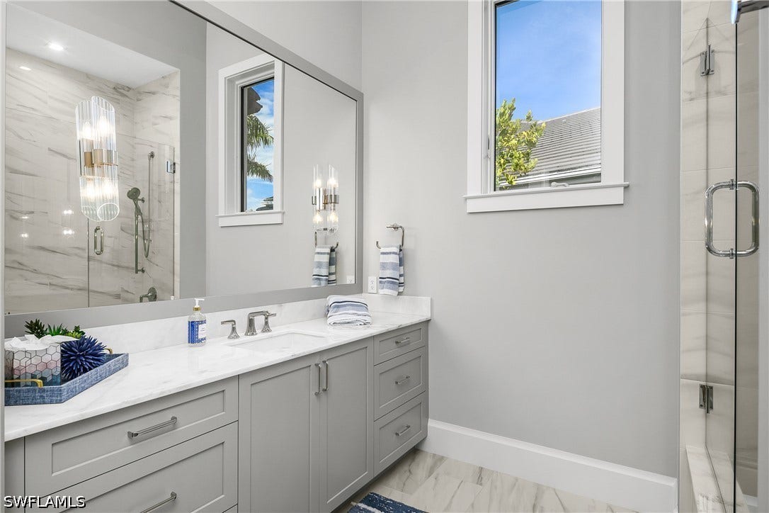 Guest ensuite bath #3 includes a shower/tub with frameless glass enclosure.