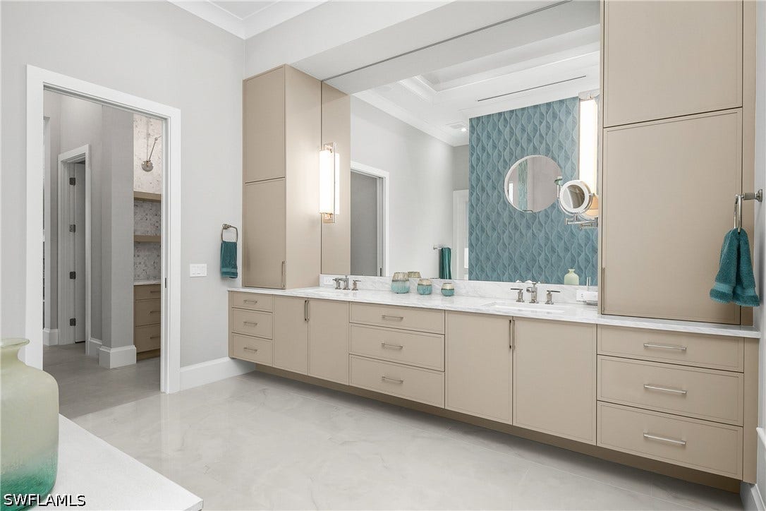 Primary bath features custom cabinetry, dual sinks, His/Hers private water closets, remote Hunter Douglas shades, walk-through shower with digital temperature controlled multiple shower heads.