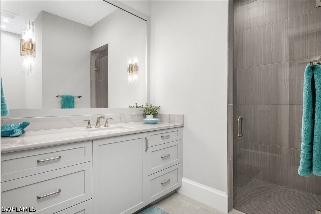 Ensuite guest bath with walk-in frameless shower.