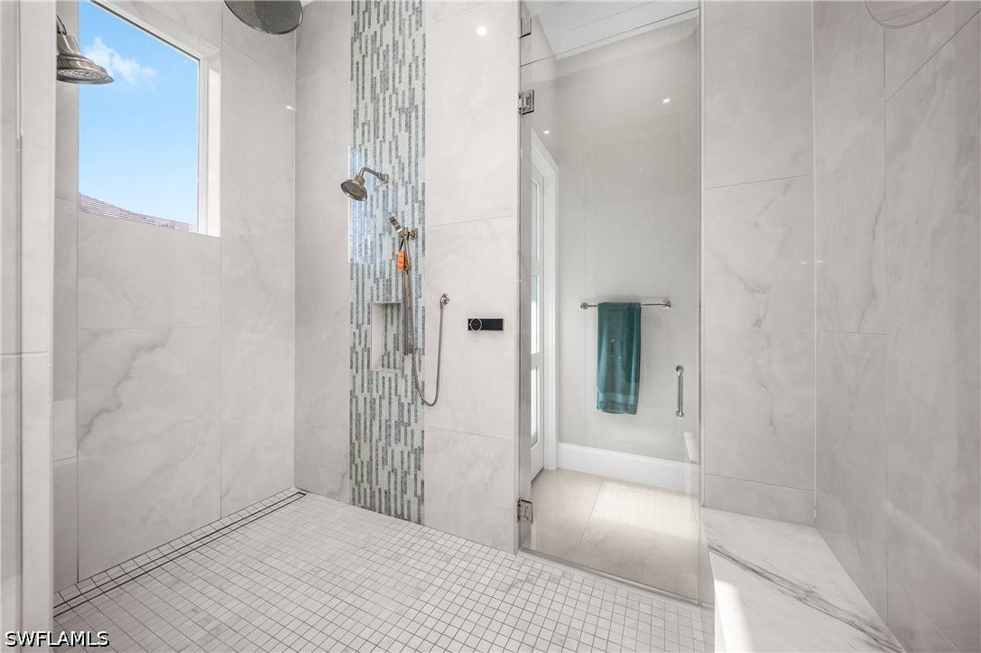 Walk-through shower with multiple shower heads, digital temperature control, gallon usage meter, and built-in shower bench.