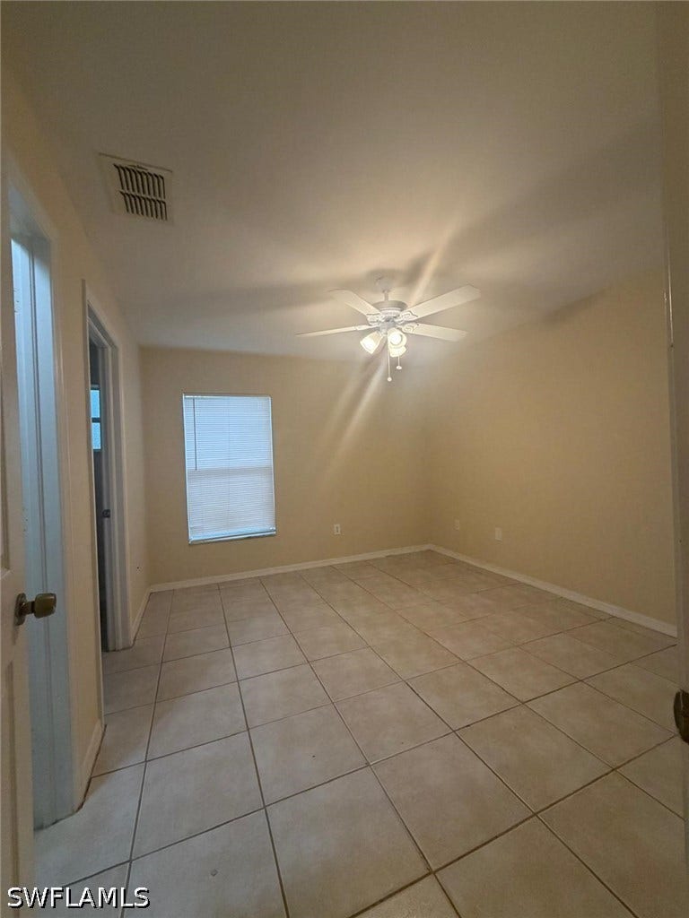 4822/4824 Leonard Boulevard S, Lehigh Acres, FL 33973 Room featuring tile flooring, a single window with blinds, and a ceiling fan with integrated lighting