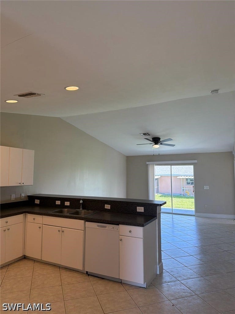 4822/4824 Leonard Boulevard S, Lehigh Acres, FL 33973 Kitchen featuring white cabinetry, dark countertops, and tile flooring