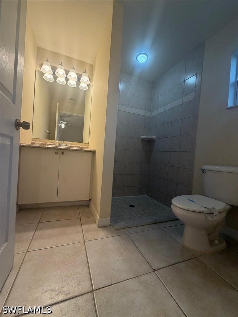 4822/4824 Leonard Boulevard S, Lehigh Acres, FL 33973 Vanity with a light-toned countertop, wall-mounted mirror, and overhead lighting