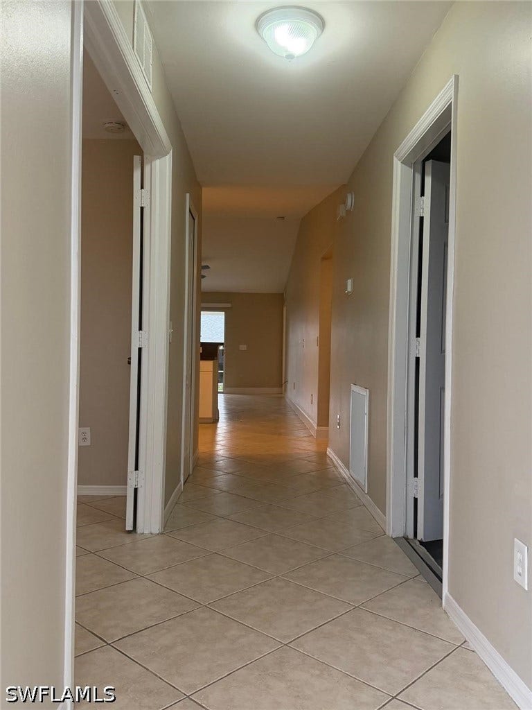 4822/4824 Leonard Boulevard S, Lehigh Acres, FL 33973 Hallway featuring neutral-toned walls, tile flooring, and flush mount lighting