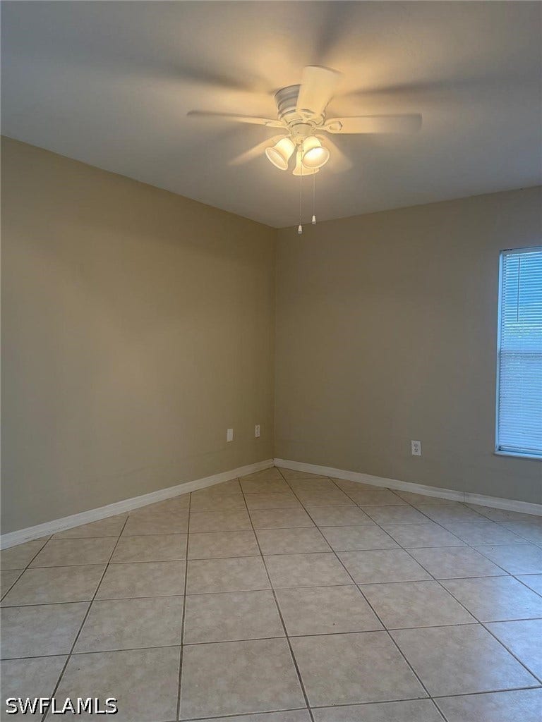 4822/4824 Leonard Boulevard S, Lehigh Acres, FL 33973 Tile flooring throughout, neutral paint palette, ceiling fan with integrated lighting, and window with blinds