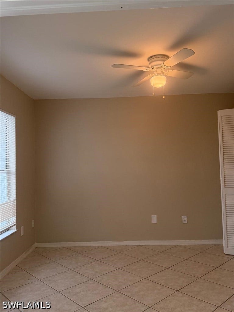 4822/4824 Leonard Boulevard S, Lehigh Acres, FL 33973 Ceiling fan with integrated lighting, tile flooring, window with horizontal blinds, and louvered bi-fold doors