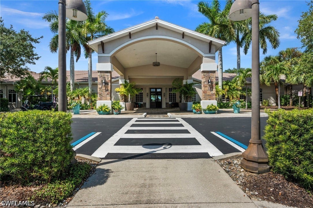 Covered entry with stone columns, tiled roofing, and integrated lighting