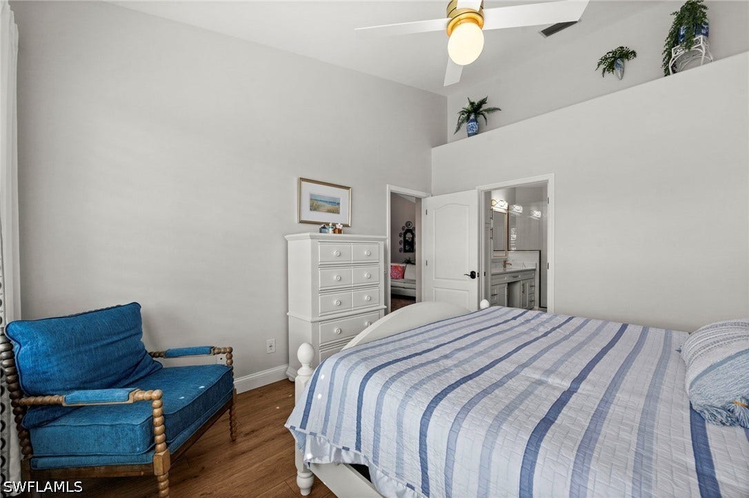 Vaulted ceiling with a ceiling fan, wood-finish flooring, and white interior doors