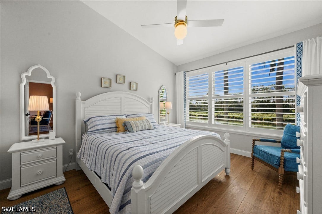 Wood-finish flooring with white plantation shutters and a ceiling fan