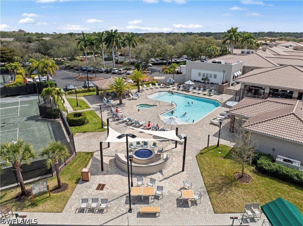 Resort-style amenities featuring a swimming pool, spa, tennis courts, and an outdoor fire pit area