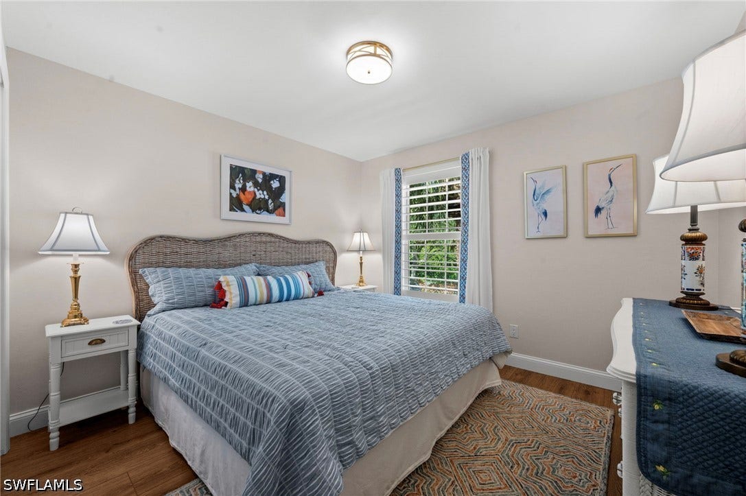 Recessed lighting, wood-finish flooring, and a large window with white louvered blinds