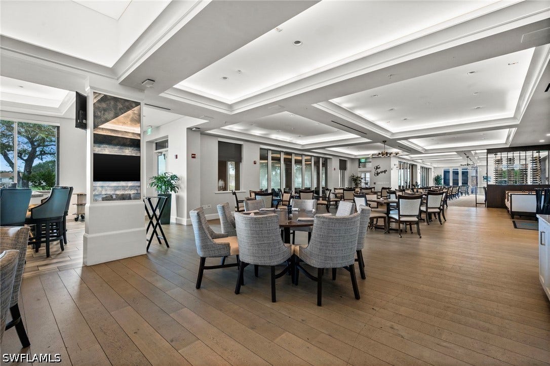 Wood-finish flooring throughout the expansive space, featuring coffered ceilings with integrated lighting