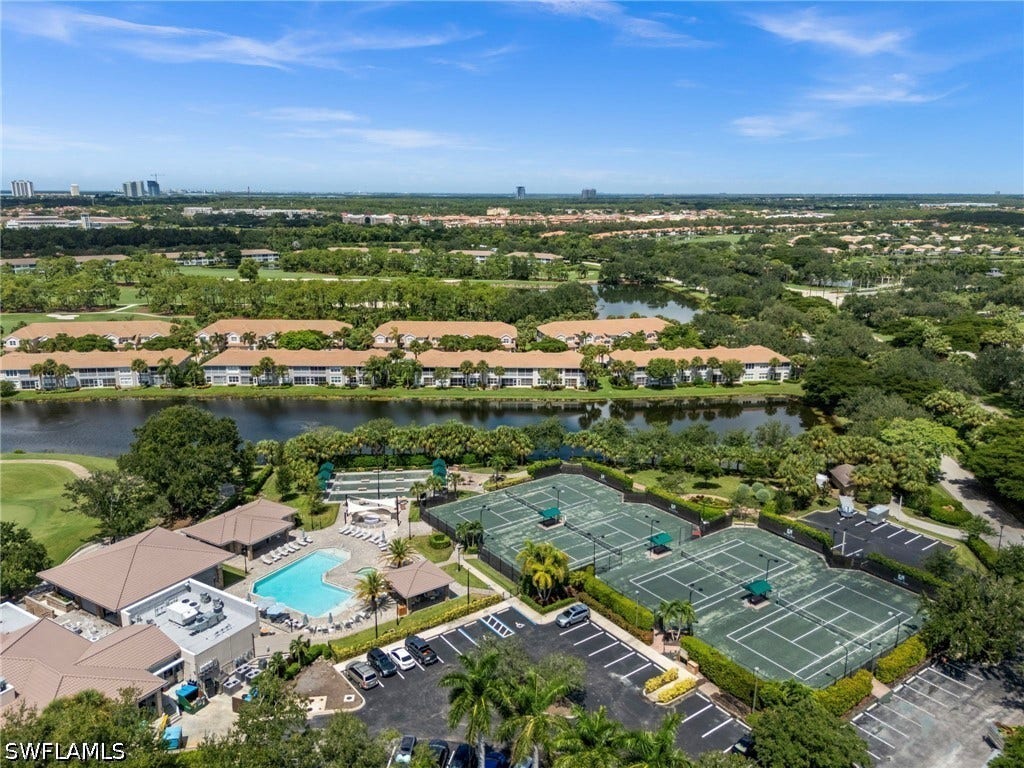 Community featuring multiple tennis courts, a large swimming pool, and a clubhouse structure