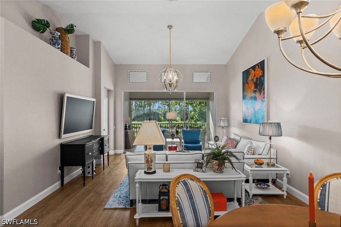 Vaulted ceilings, wood-finish flooring, and a decorative chandelier