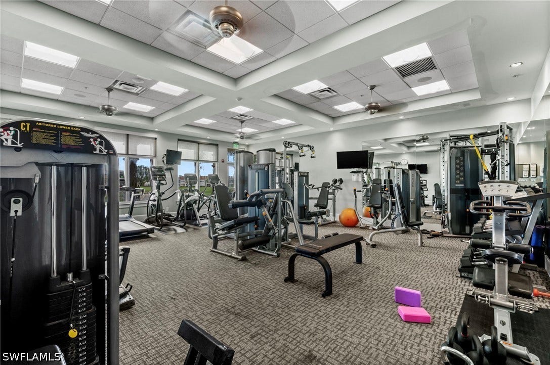 Fitness center featuring cardio equipment, strength training machines, mirrored walls, ceiling fans, and recessed lighting