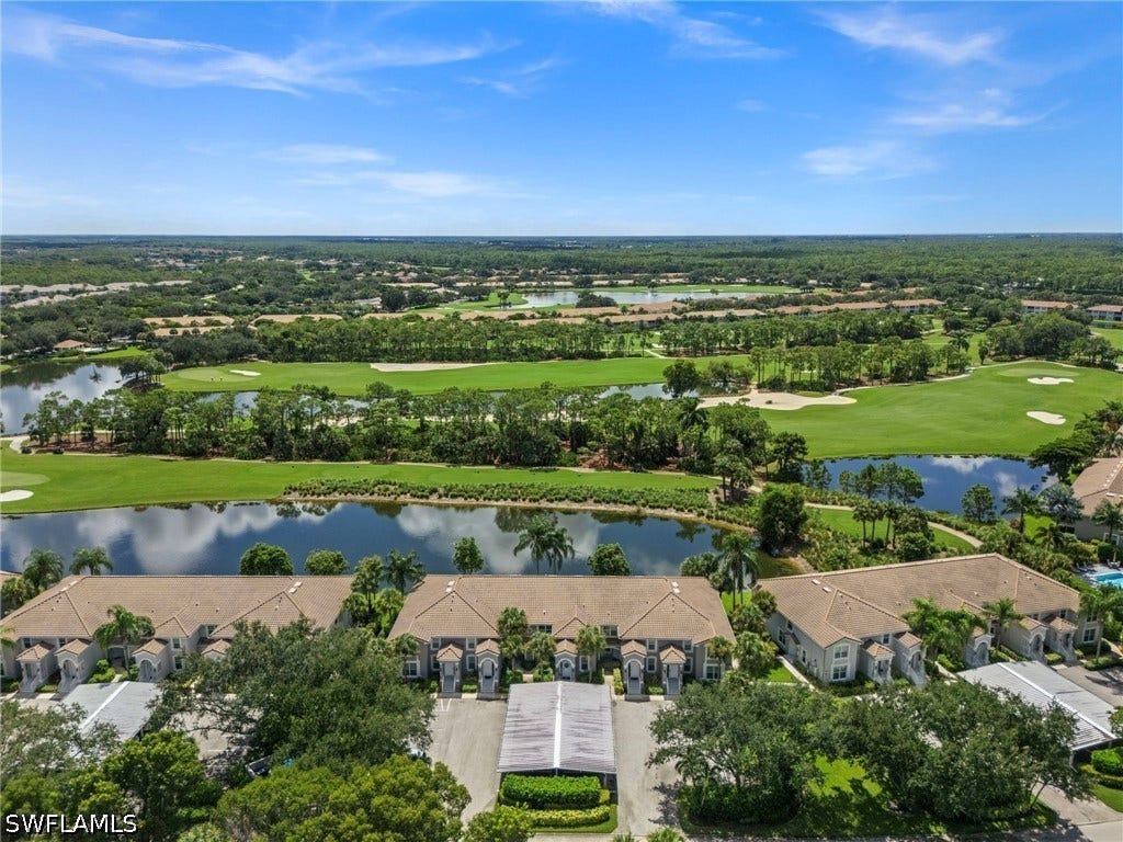 Golf course frontage with multiple water features, mature landscaping, and private parking structures