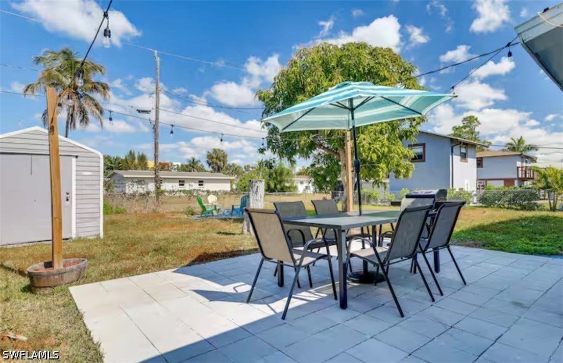 4630 New Haven Drive, Fort Myers, FL 33908 Paver patio with a built-in outdoor lighting system, a storage shed, and mature palm trees
