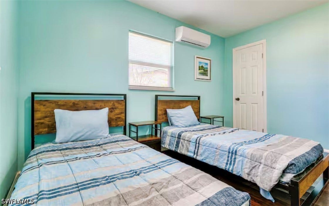 4630 New Haven Drive, Fort Myers, FL 33908 Wood-finish flooring, white paneled door, and a wall-mounted mini-split HVAC unit