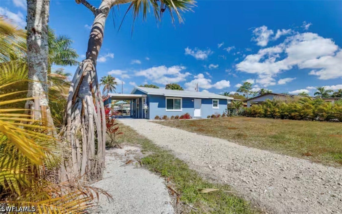 4630 New Haven Drive, Fort Myers, FL 33908 Single-story residence with a carport, gravel driveway, and a light blue exterior
