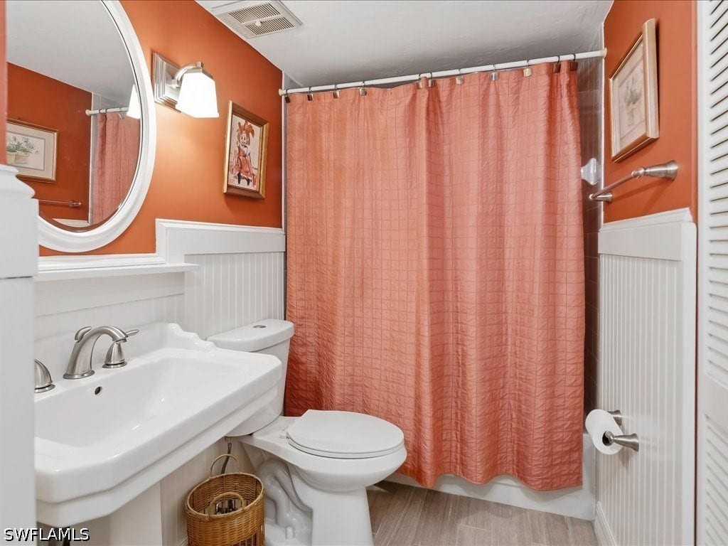 Updated guest bath with tub and shower, pedestal sink, comfort level toilet, beadboard and decor mirror and lights.