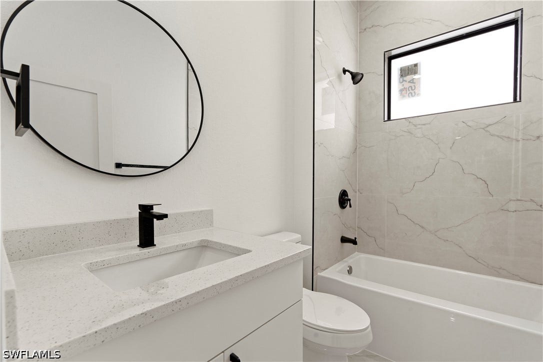 532 Lone Star Lane, Lehigh Acres, FL 33974 White vanity with a speckled countertop, undermount sink, and black faucet