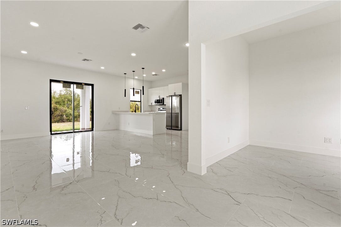 532 Lone Star Lane, Lehigh Acres, FL 33974 Spacious interior featuring white tile flooring, recessed lighting, and sliding glass doors