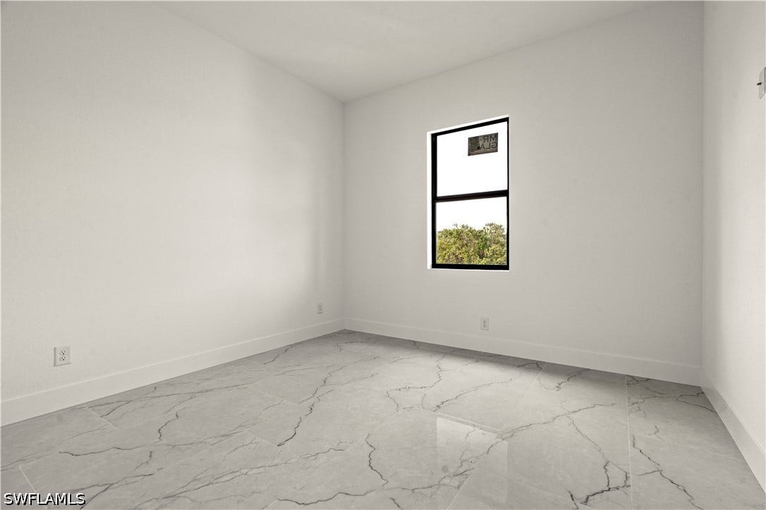 532 Lone Star Lane, Lehigh Acres, FL 33974 White walls, black-framed window, and large format tiled flooring
