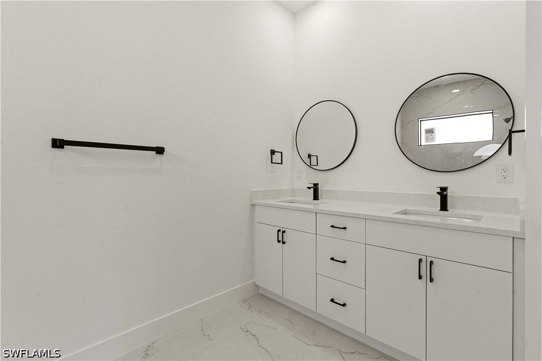 532 Lone Star Lane, Lehigh Acres, FL 33974 Dual vanity with white cabinetry, light-toned countertops, and matte black fixtures
