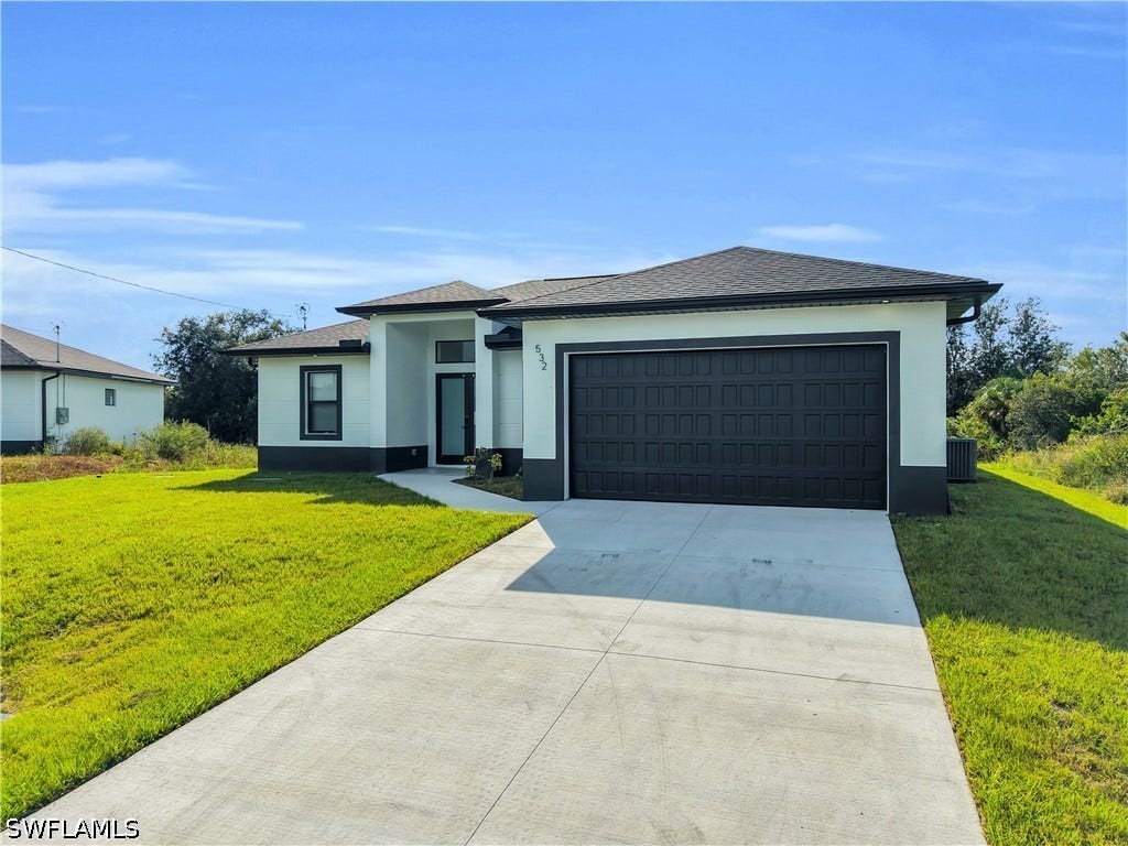 532 Lone Star Lane, Lehigh Acres, FL 33974 Contemporary stucco exterior with a dark-paneled garage door, concrete driveway, front walkway, and a dark asphalt shingle roof