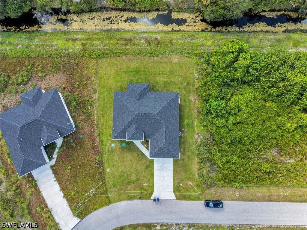 532 Lone Star Lane, Lehigh Acres, FL 33974 New construction property with dark shingle roofing, a concrete driveway, and a grass lawn