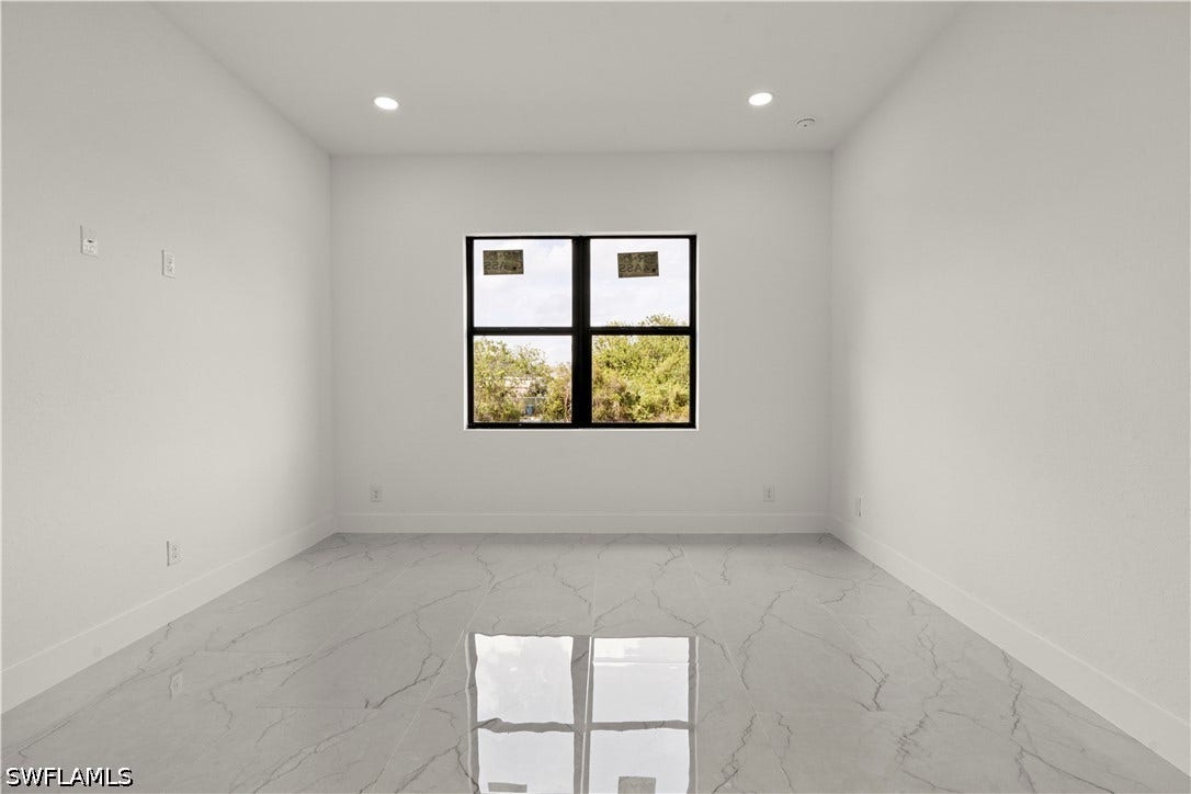 532 Lone Star Lane, Lehigh Acres, FL 33974 Recessed lighting, large window with black framing, white walls, and marble-look flooring