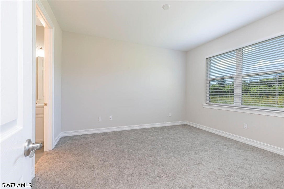 Spare room with light carpet and baseboards