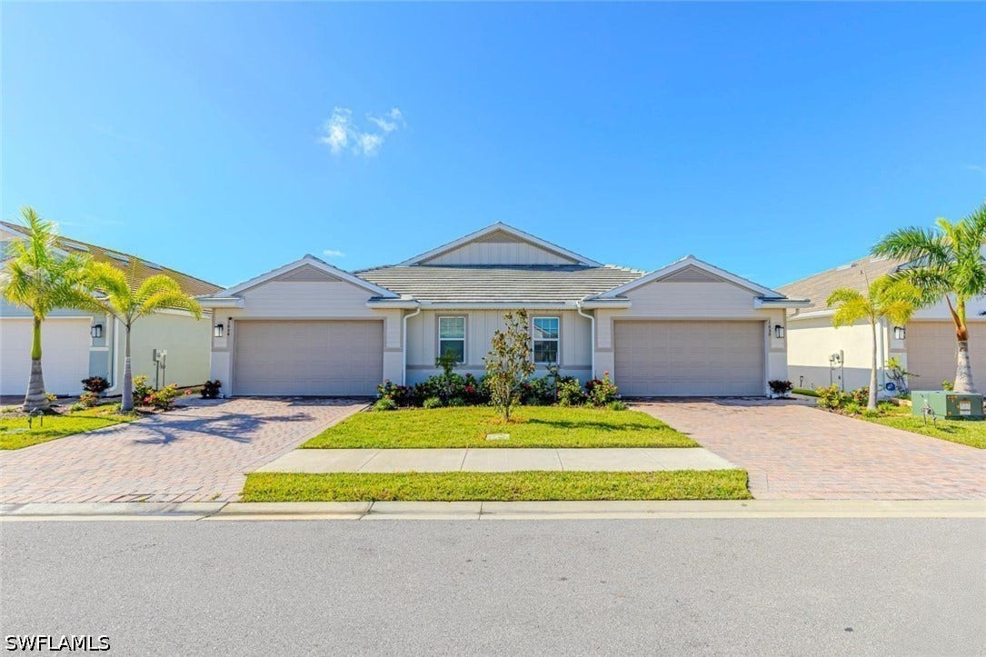 Ranch-style home with a front lawn, driveway, and a garage