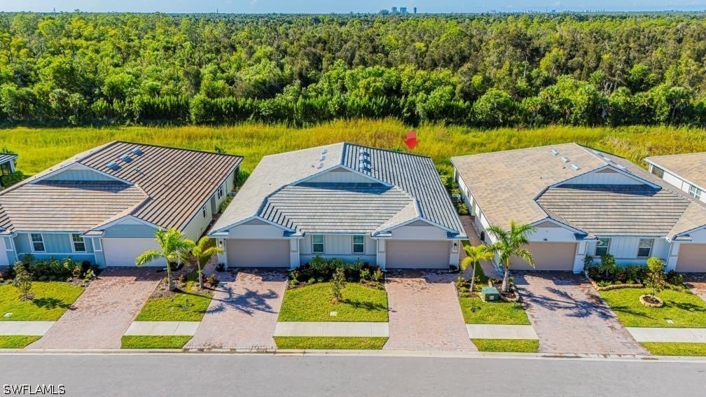 Aerial view of property and surrounding area with a heavily wooded area