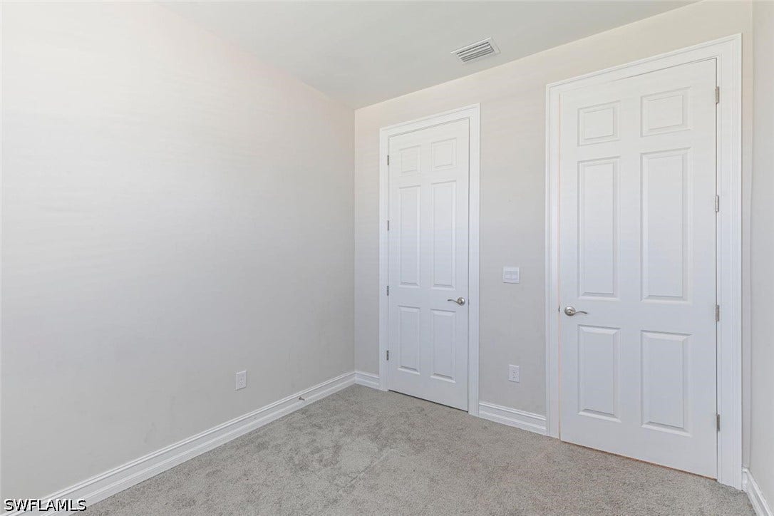 Unfurnished bedroom with carpet floors and baseboards