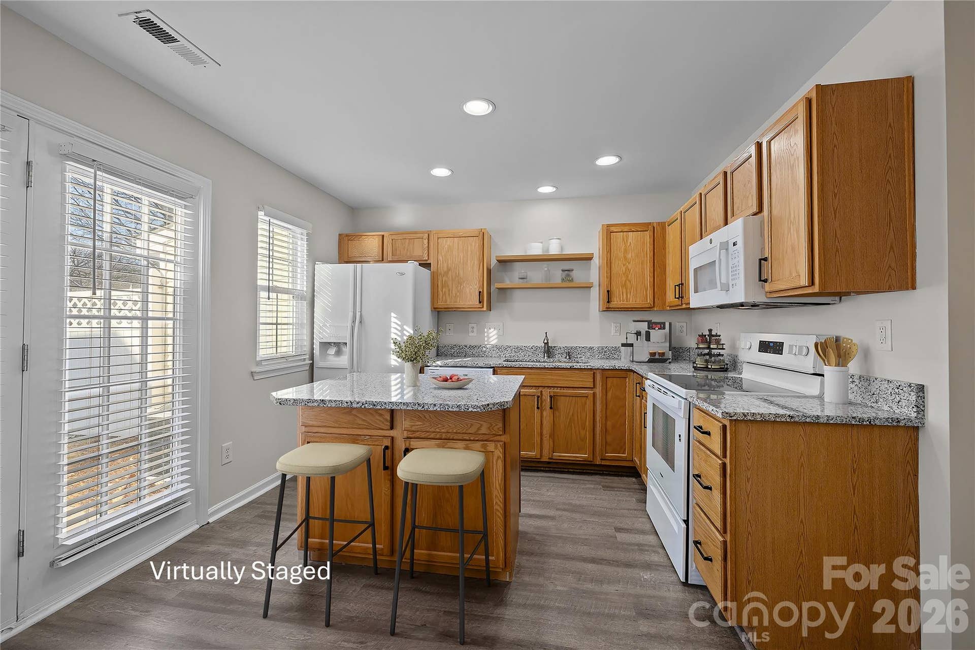 Updated kitchen features new granite countertops, new undermount sink with modern faucet, new range, new dishwasher, new open shelving.
