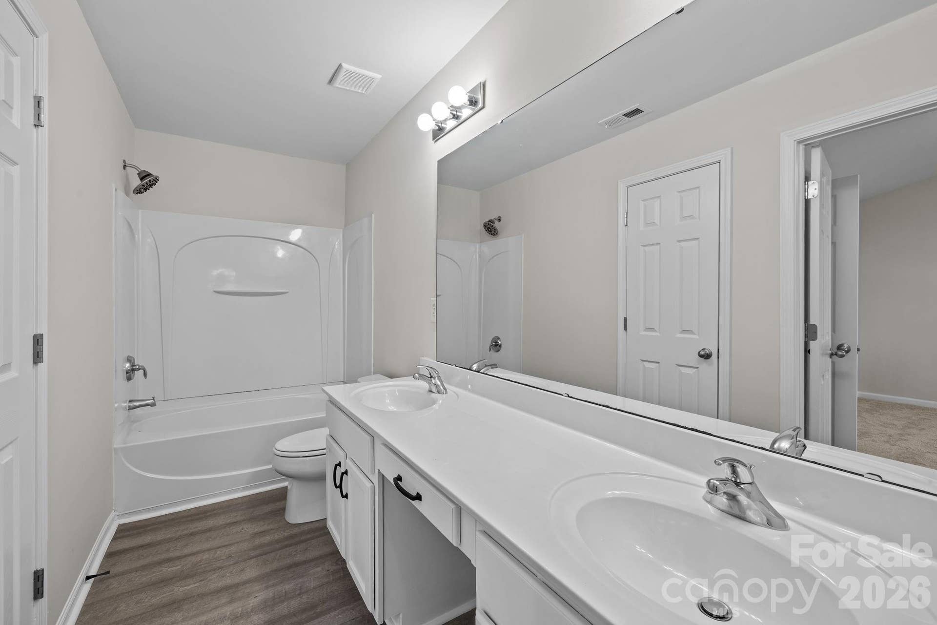 En-suite bathroom with expansive, double sink vanity, tub/shower combination, space for vanity stool, linen closet.