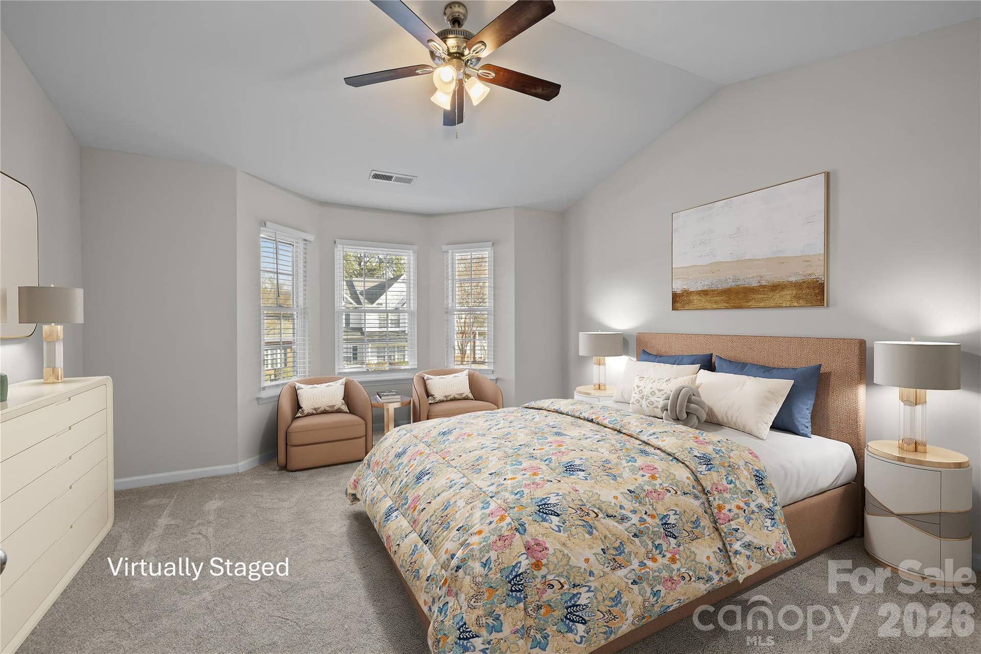 Spacious primary bedroom suite with vaulted ceiling and bay window detail that brings in natural light and architectural interest, as well as room for a sitting area.