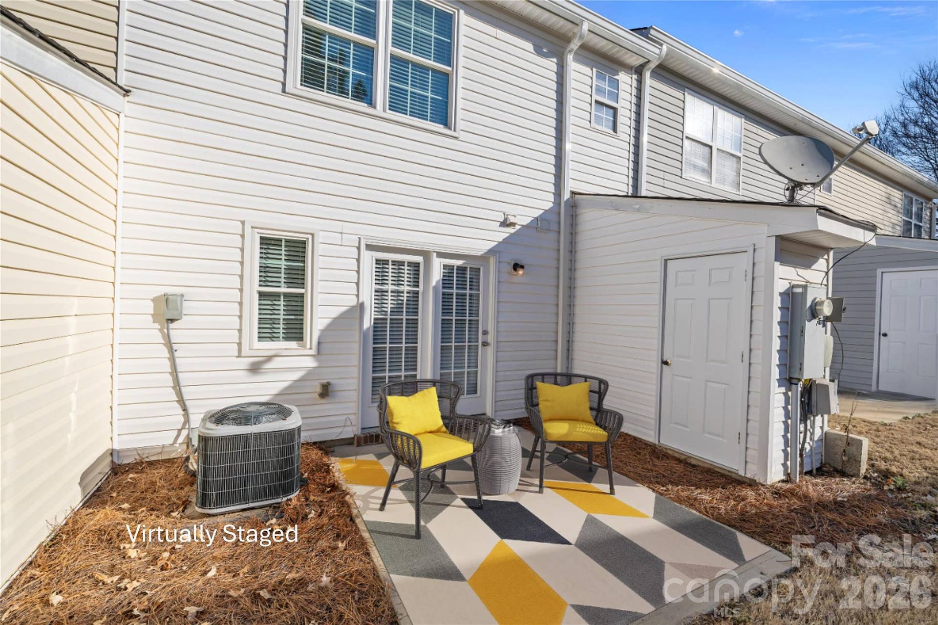 Private patio with privacy fencing on one side and exterior storage room on the other side.