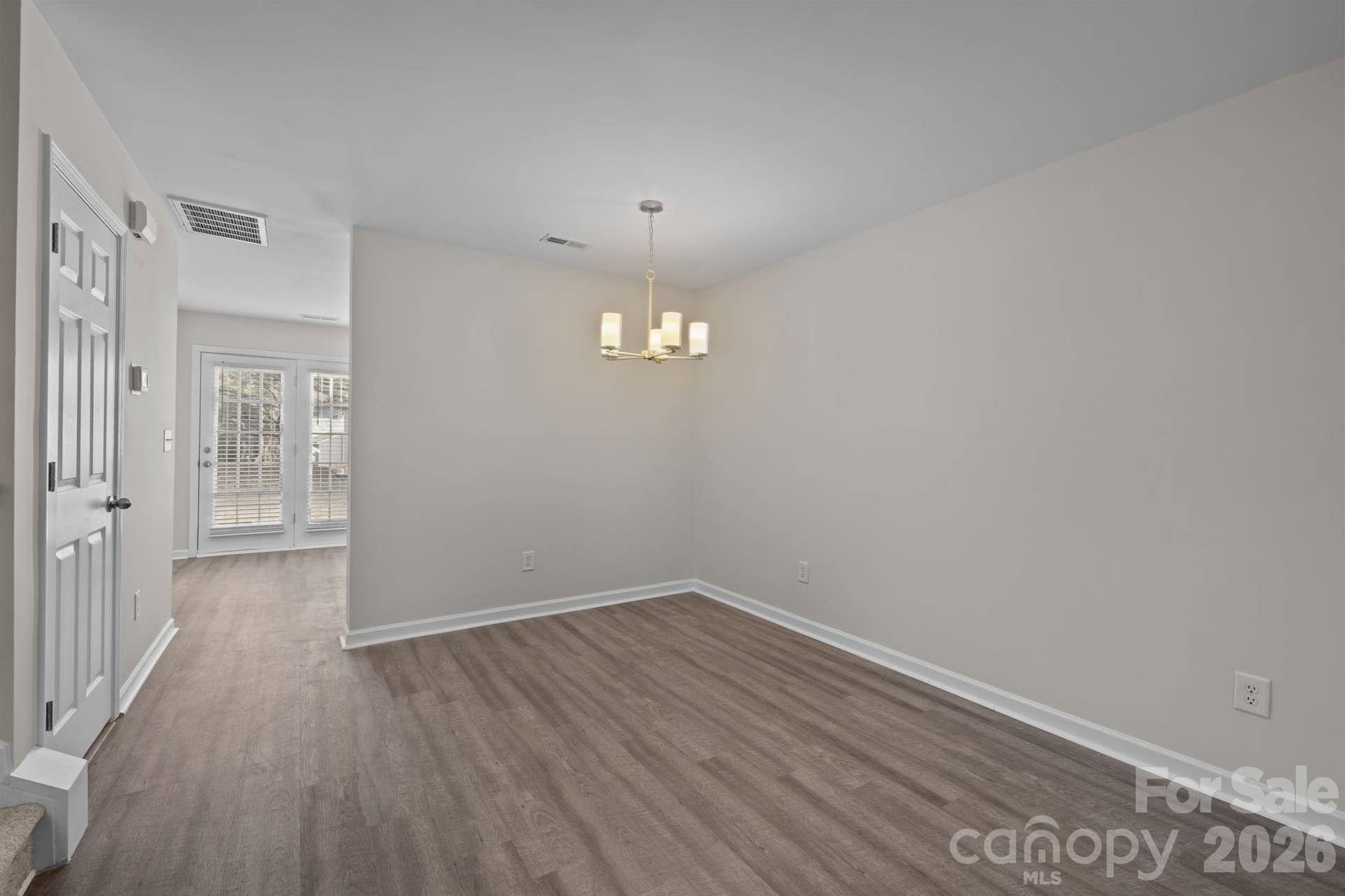 Spacious dining area features a brand new chandelier, fresh neutral paint.