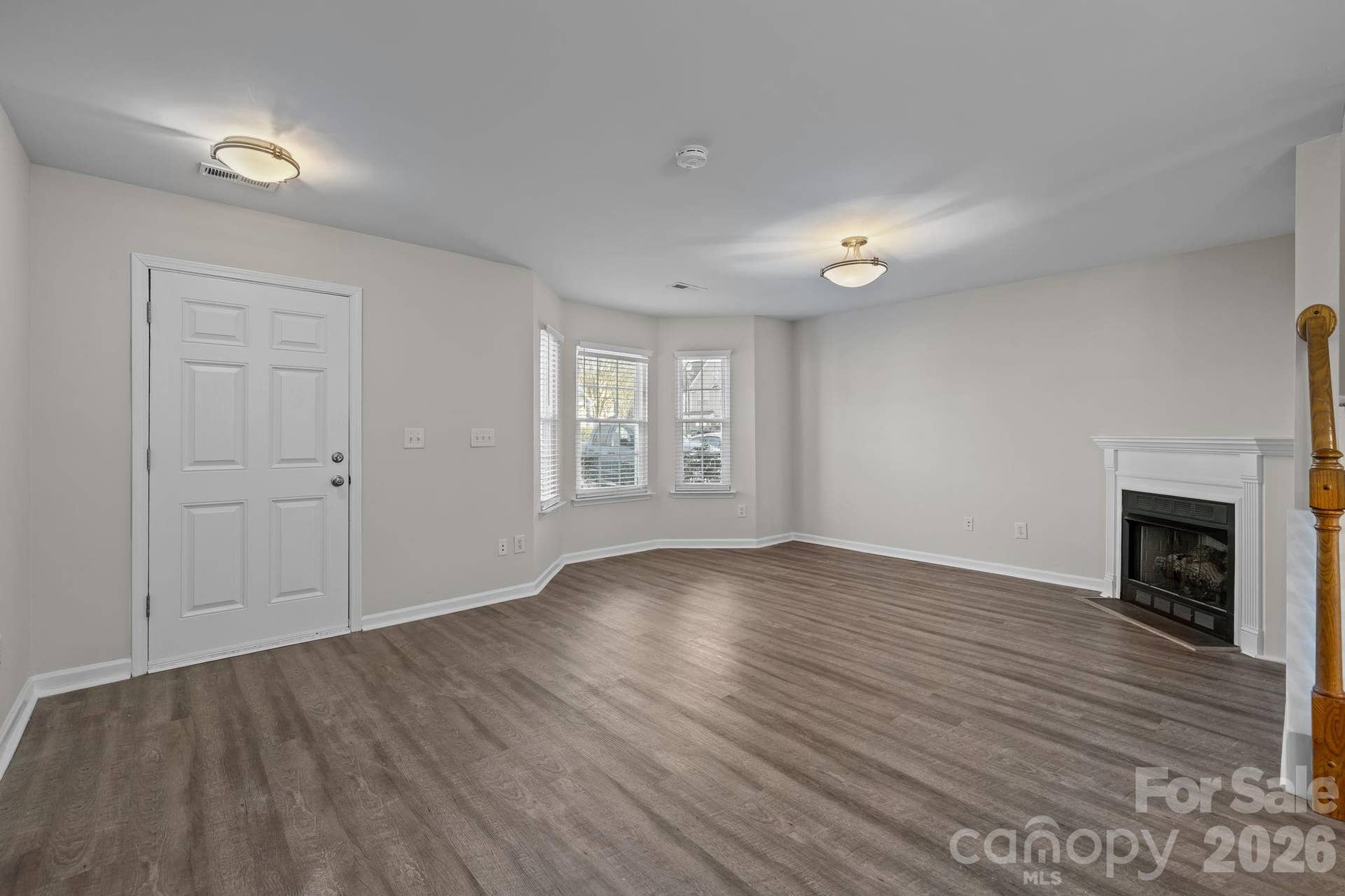 Living room features low maintenance vinyl plank flooring, gas log fireplace, bay window, brand new light fixtures.