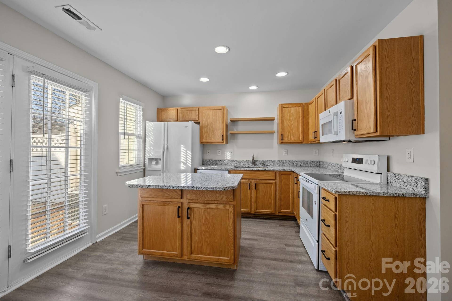 Kitchen offers generous cabinet and counter space, recessed lighting, great natural light, low maintenance flooring.