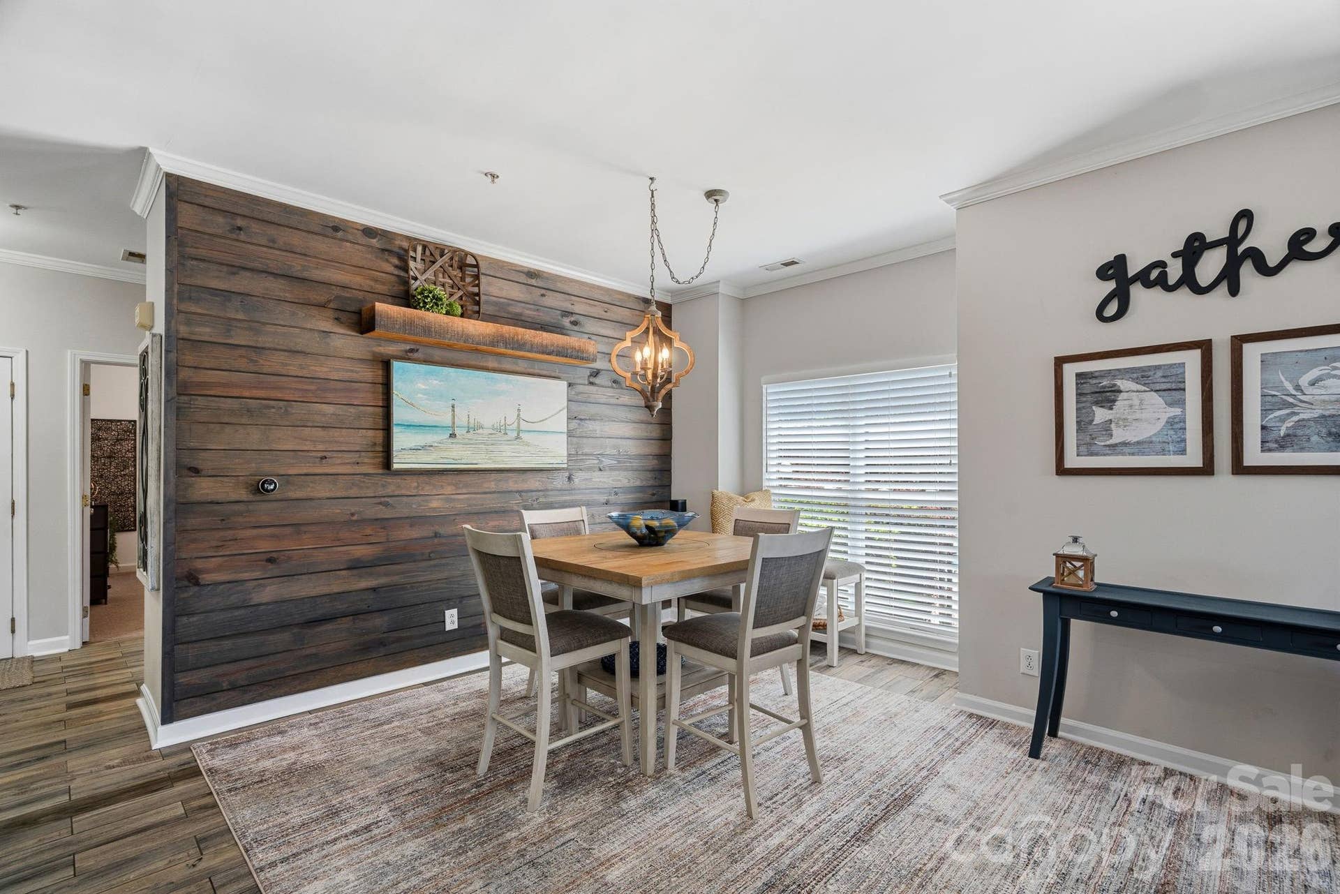 Opposite the kitchen, the dining area features a nautical-inspired shiplap accent wall and offers relaxing water views.